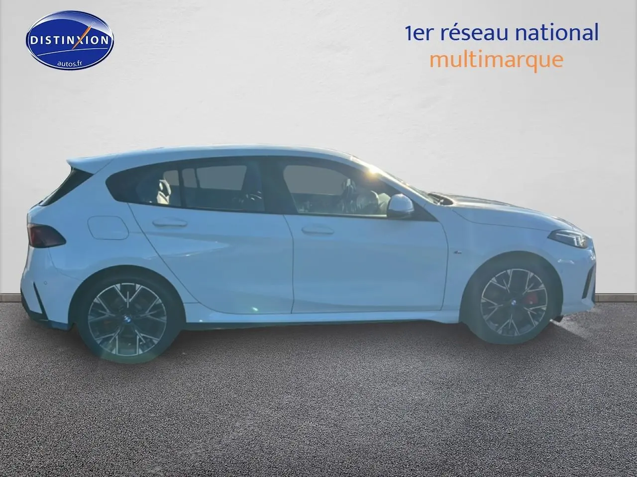 Profil droit d'une BMW Série 1 blanche alpin avec jantes 18 pouces bicolores et finition M Sport Pro.