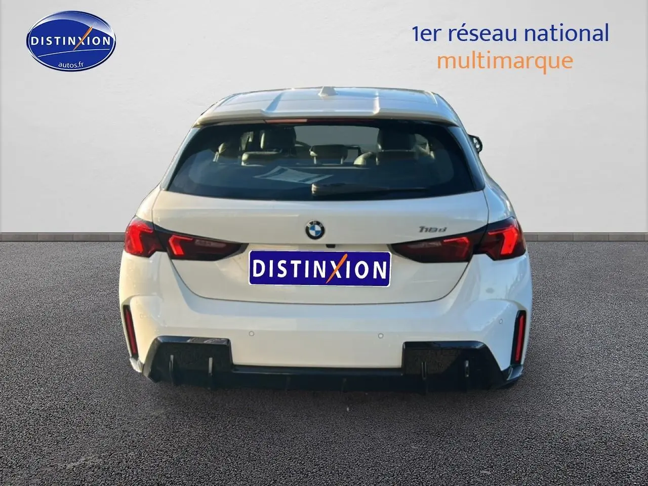 Vue arrière d'une BMW Série 1 blanche alpine 118d avec feux LED et diffuseur noir sportif.