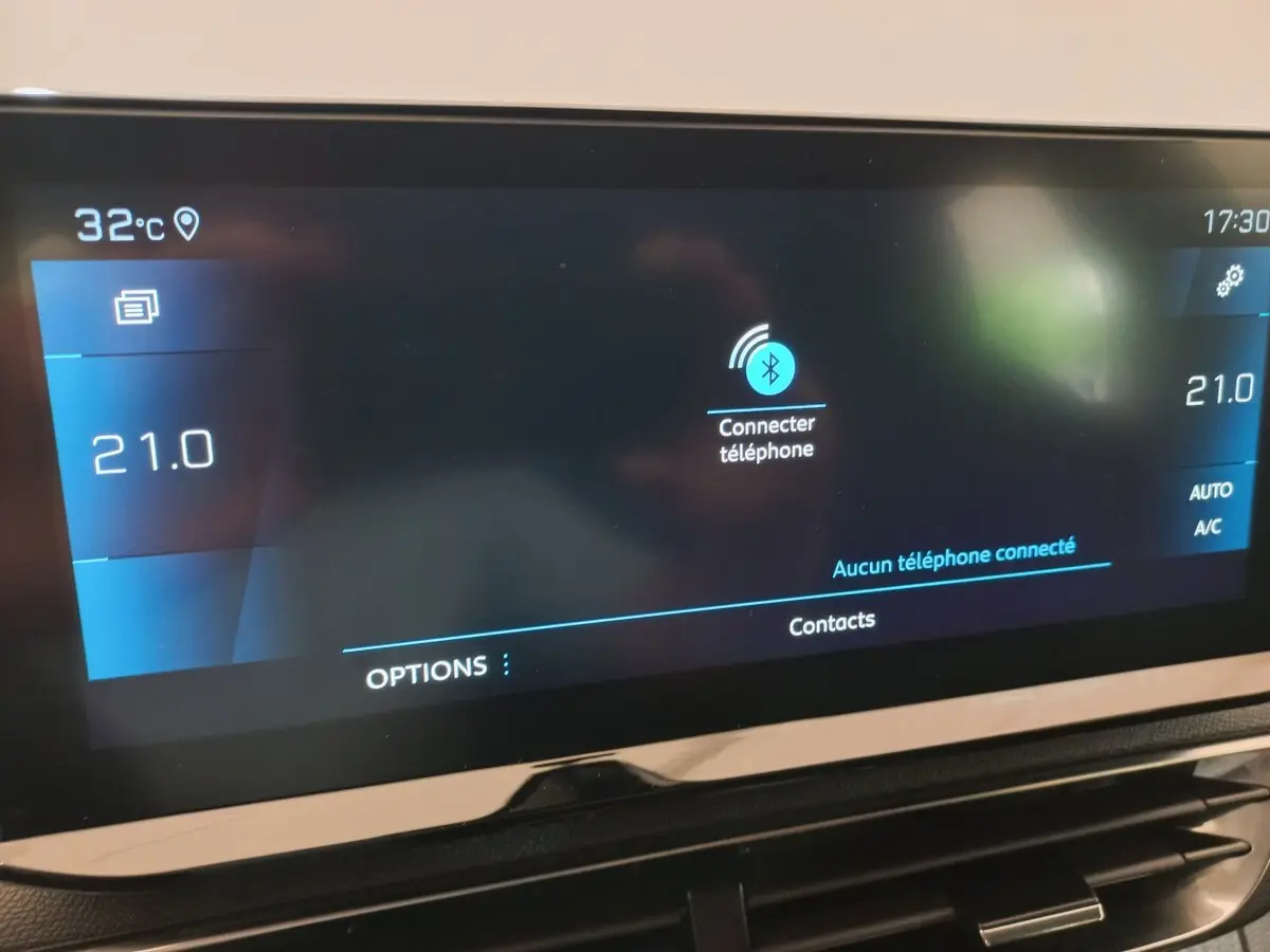 Écran tactile central du tableau de bord du Peugeot 3008 noir, affichant la connexion Bluetooth et la température à 21°C.
