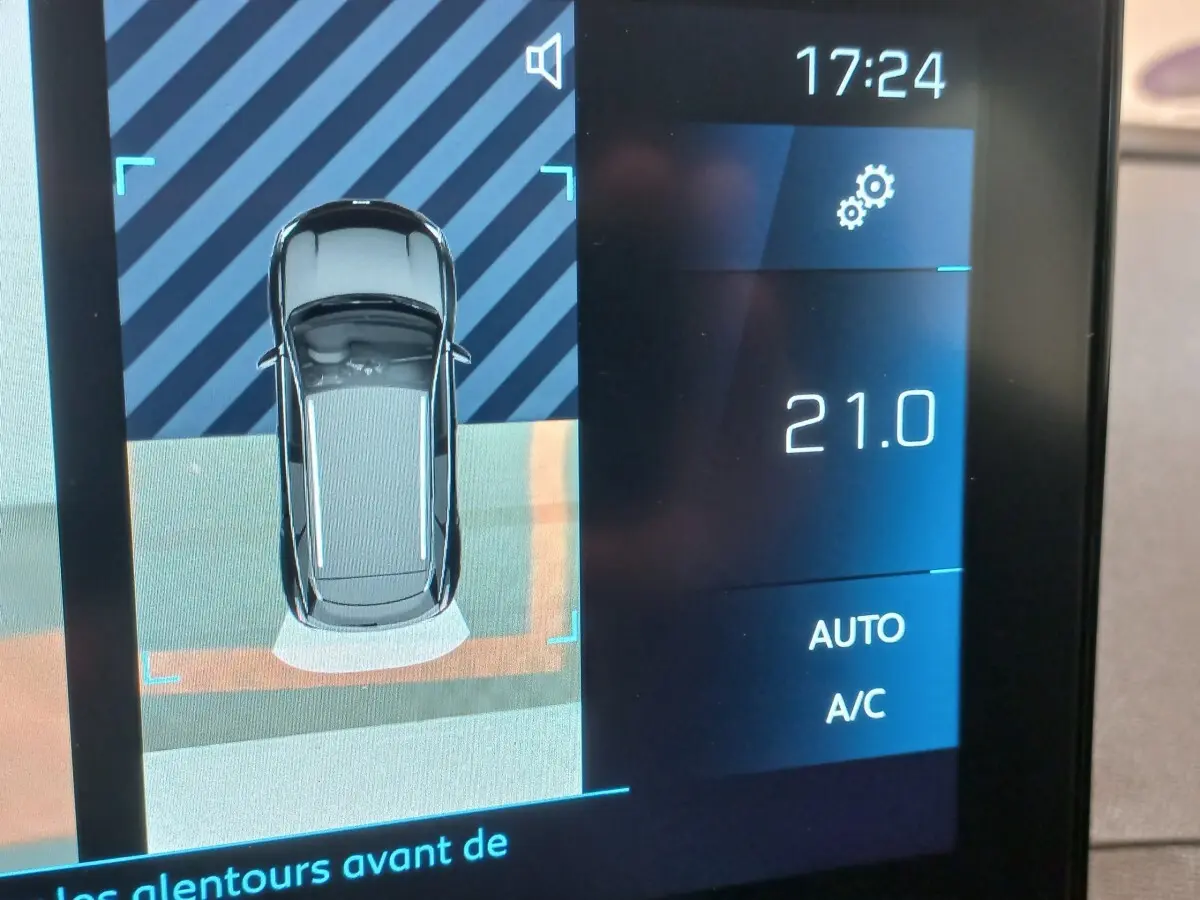 Affichage tactile intérieur montrant la vue aérienne du Peugeot 3008 noir en stationnement avec température à 21°C.