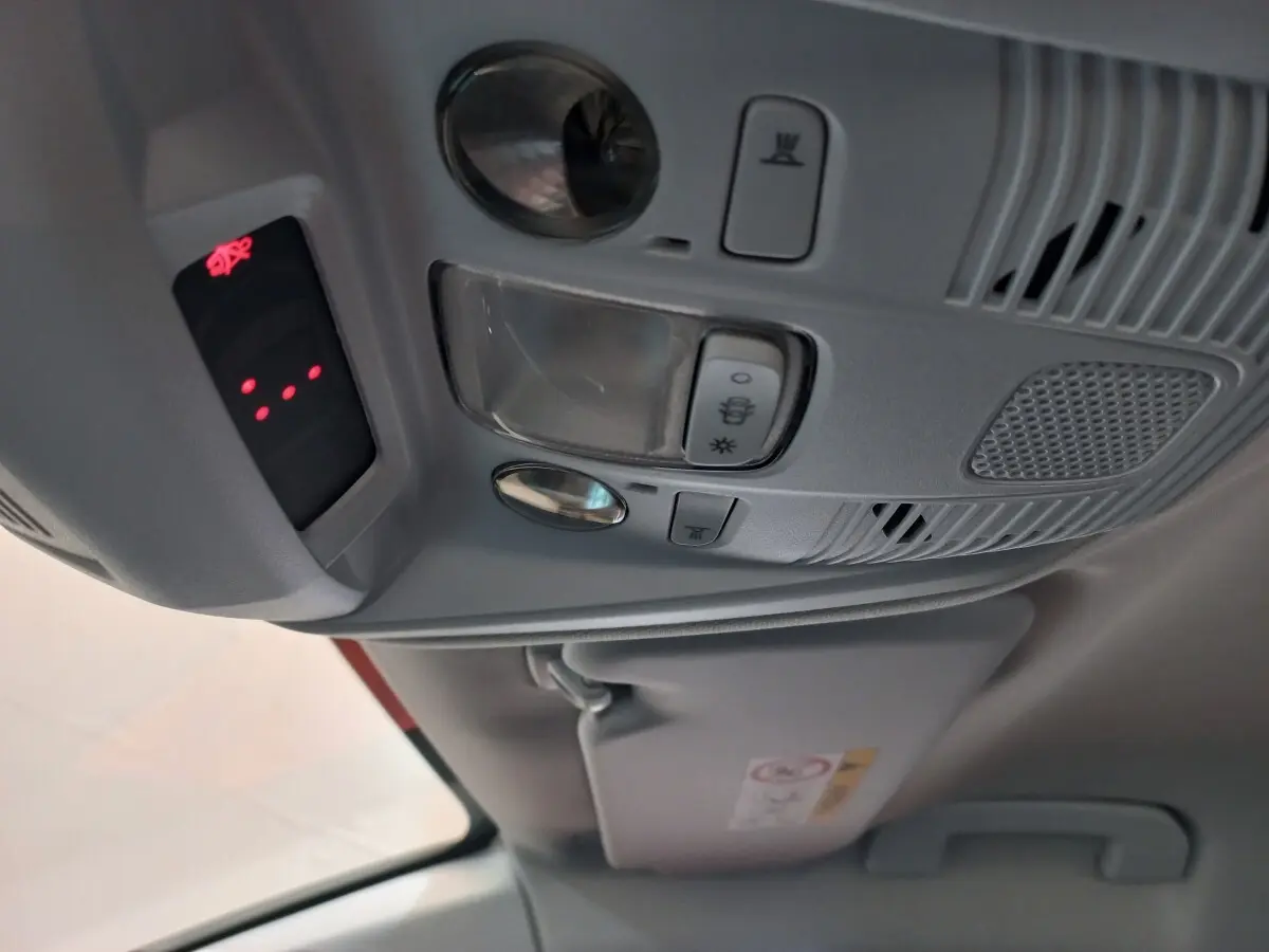 Vue intérieure en gros plan du plafonnier gris avec commandes d’éclairage et alerte ceinture du Peugeot 3008 noir 2022.