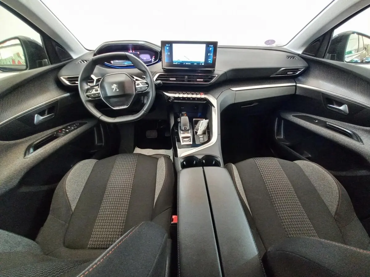 Intérieur Peugeot 3008 2022 vue avant, tableau de bord noir avec écran tactile central et volant compact multifonctions.