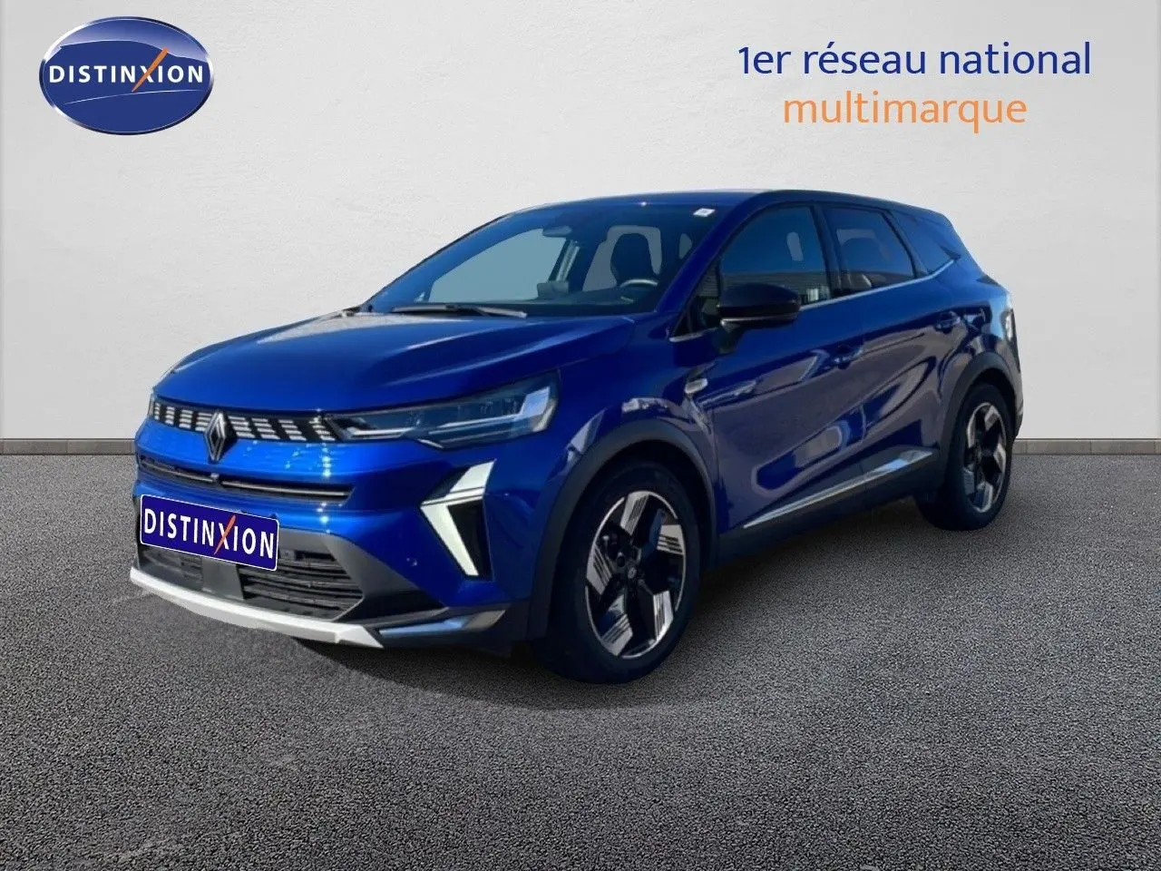 Renault Symbioz bleu Iron Metal en 3/4 avant droit, SUV hybride avec calandre distinctive et jantes stylisées.