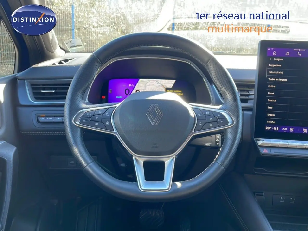 Vue intérieure centrée sur le volant noir perforé et le tableau de bord numérique du Renault Symbioz bleu Iron Metal.