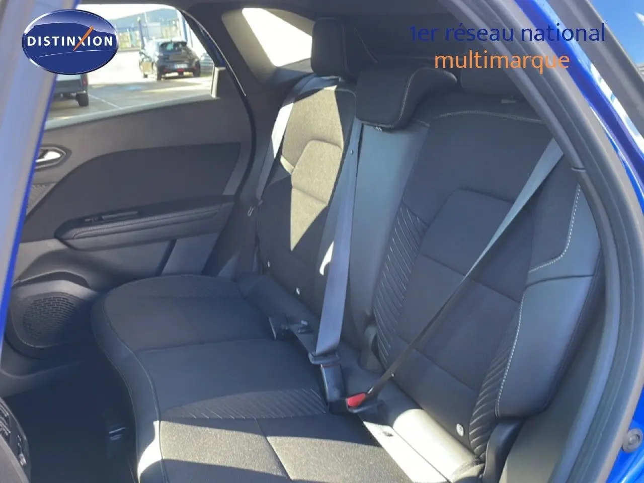 Vue intérieure côté droit des sièges arrière en tissu noir du Renault Symbioz bleu iron metal, avec ceinture de sécurité attachée.