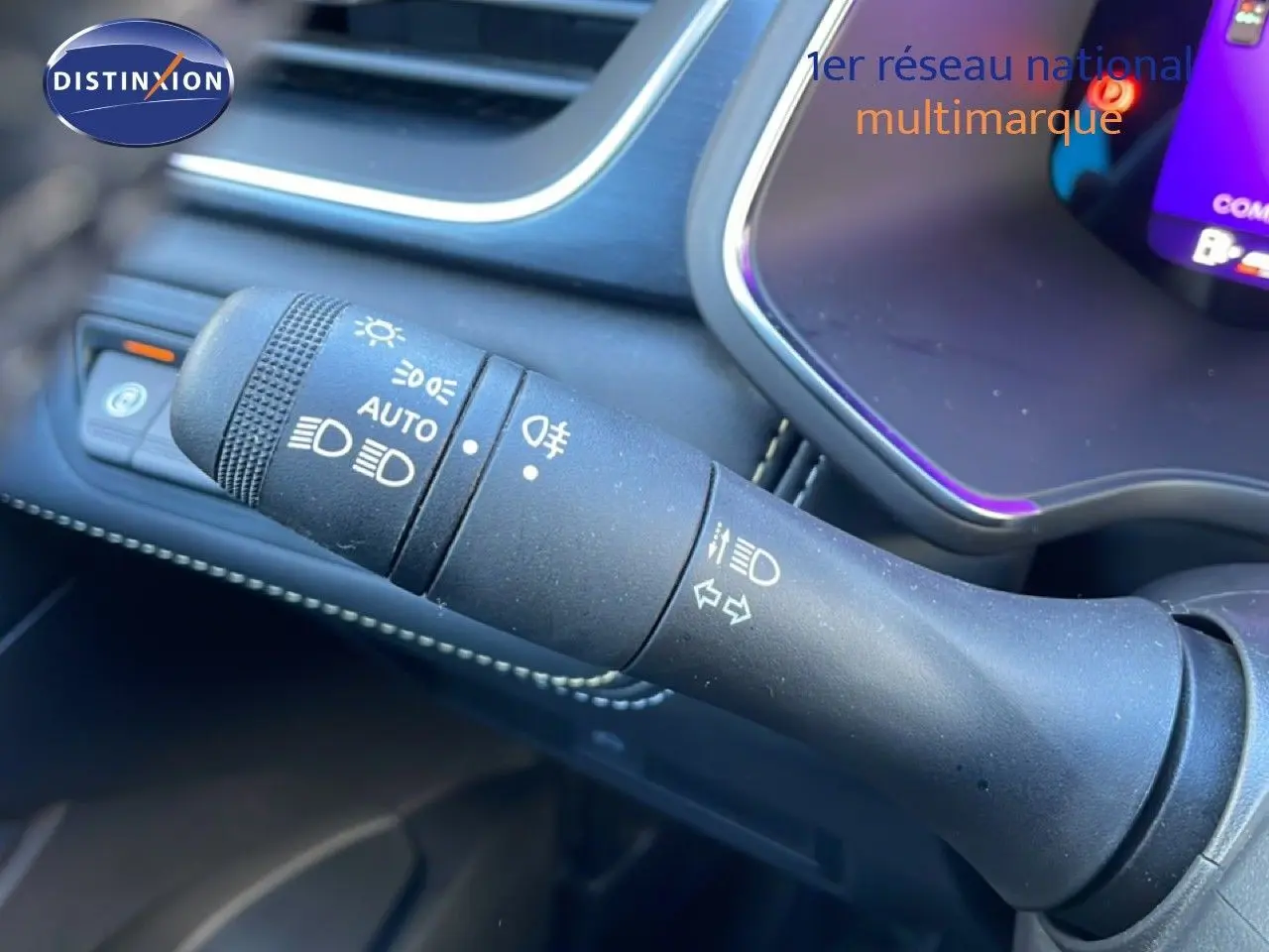 Gros plan sur la commande des phares et clignotants dans l’habitacle noir du Renault Symbioz bleu Iron Metal.
