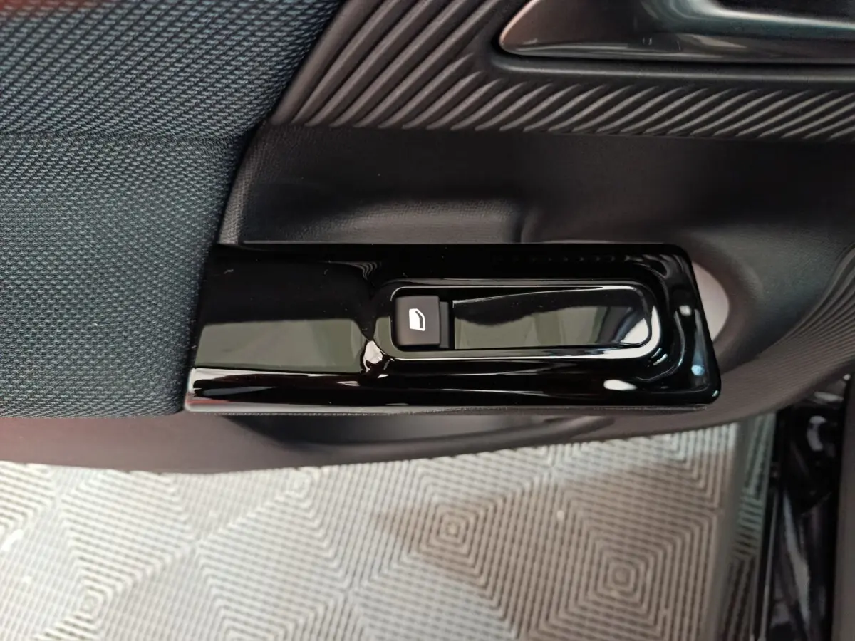Gros plan sur la commande de verrouillage de porte noire intégrée à la garniture intérieure côté conducteur du Citroën C5 Hybride.