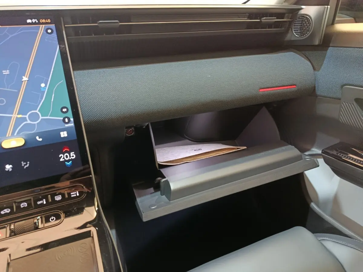 Intérieur de la CITROEN C5 Hybride 2026, vue du tableau de bord côté passager avec boîte à gants ouverte et écran tactile visible.