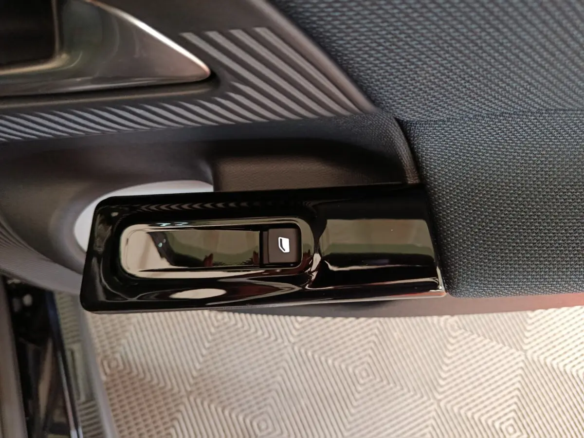 Détail de la commande électrique de lève-vitre sur la porte côté gauche d’une Citroën C5 hybride noire.