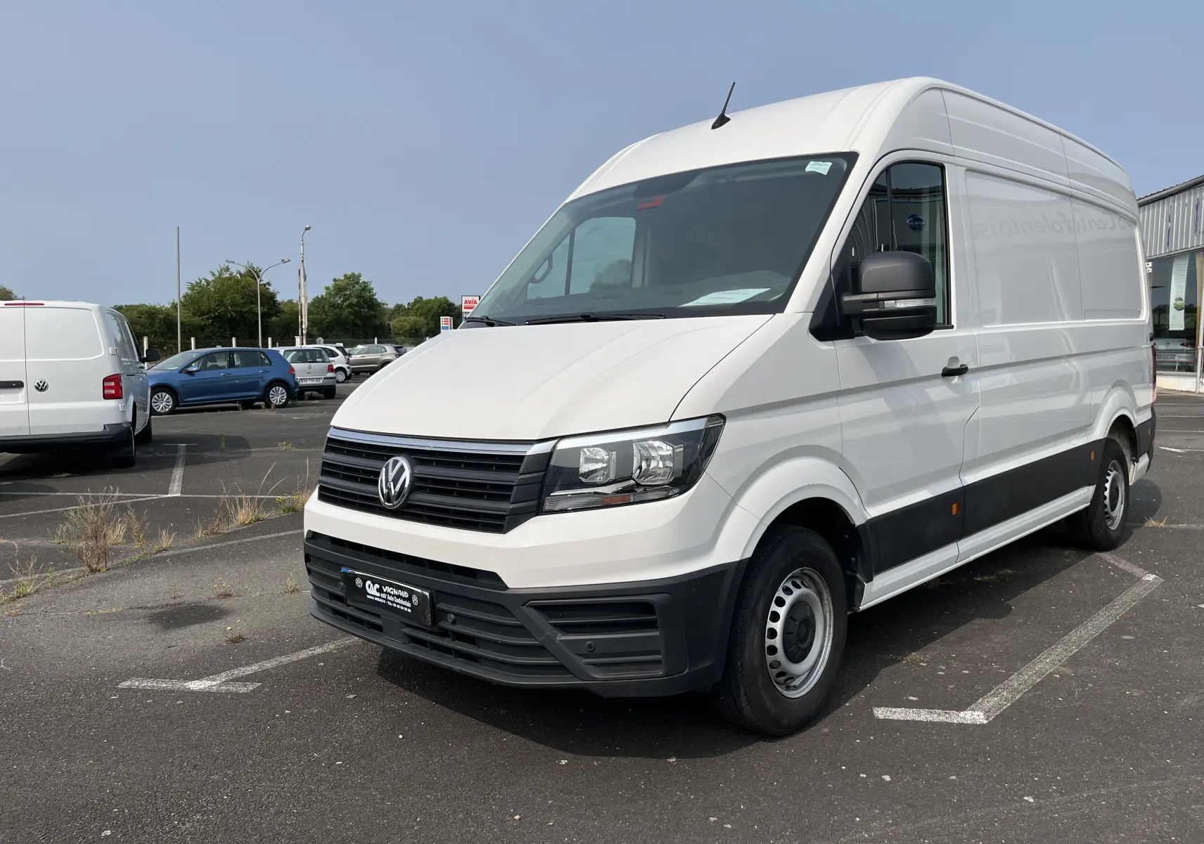Vue 3/4 avant droite d’un Volkswagen Crafter fourgon blanc de 2019 avec calandre noire et jantes acier.