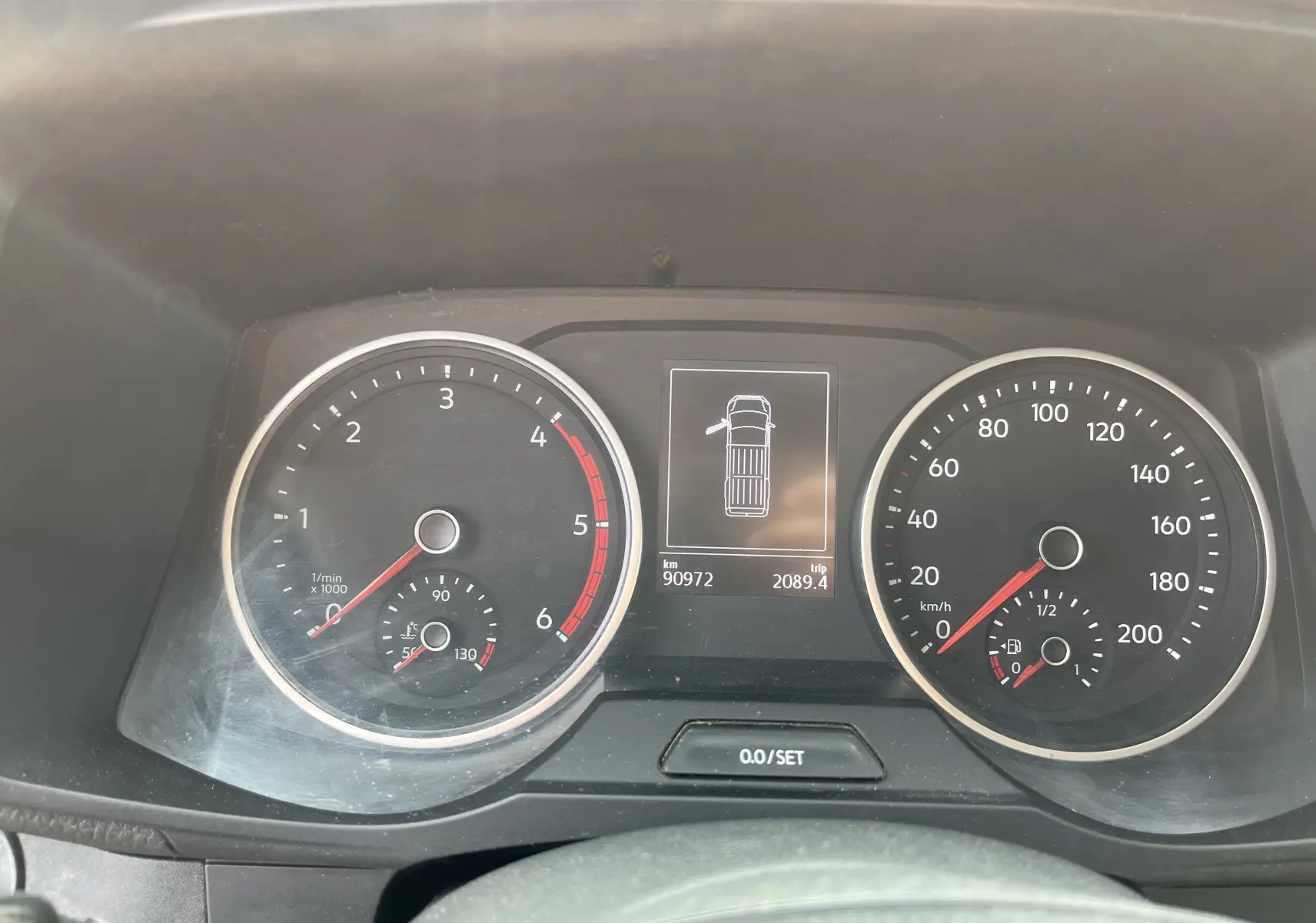 Tableau de bord du Volkswagen Crafter blanc 2019 montrant compte-tours, vitesse et écran central avec porte ouverte à gauche.