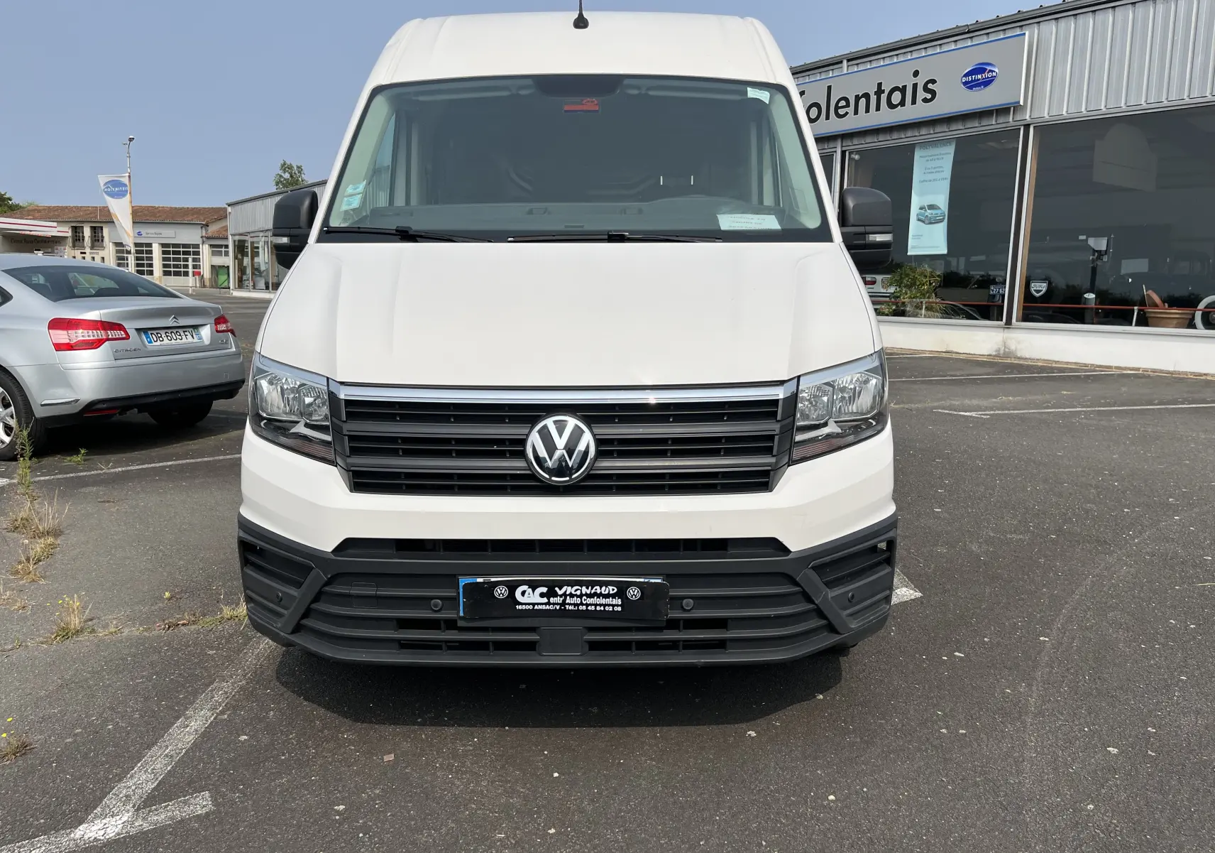 Vue frontale d'un Volkswagen Crafter blanc 2019 avec calandre noire et logo VW centré sur un parking.
