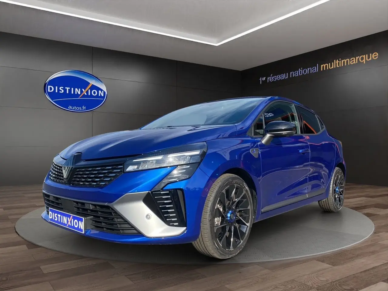 Renault Clio V TCE 90 Esprit Alpine bleu Iron vue 3/4 avant avec jantes noires et détails argentés.