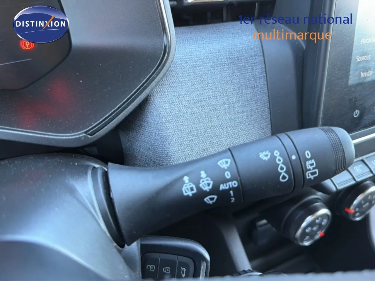 Gros plan sur la commande d’essuie-glace à gauche du volant dans l’habitacle d’une Renault Clio blanche 2025.