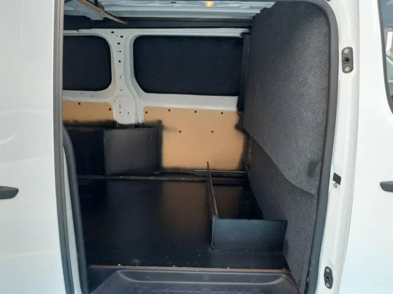 Vue intérieure du coffre du Peugeot Expert Fourgon blanc XL, montrant l'espace de chargement avec cloison et revêtement noir.