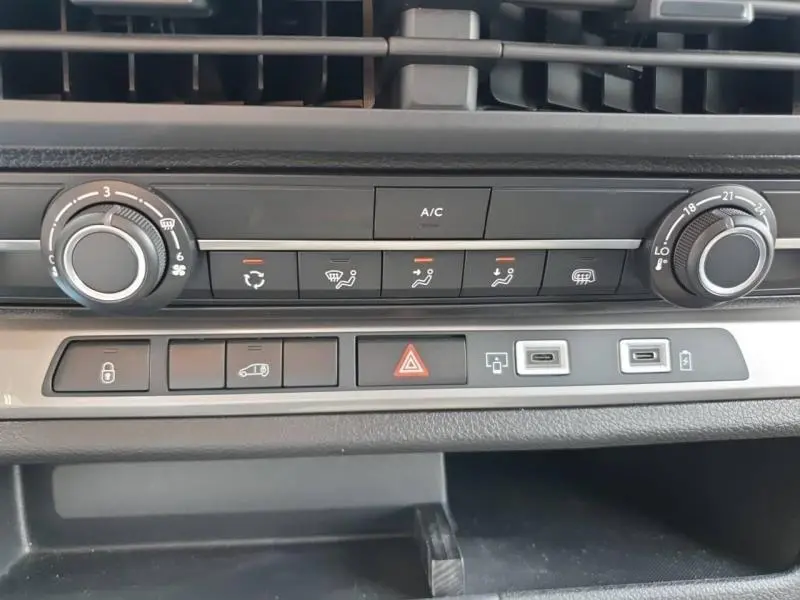 Vue rapprochée de la console centrale du Peugeot Expert Fourgon blanc, montrant les commandes de climatisation et ports USB.