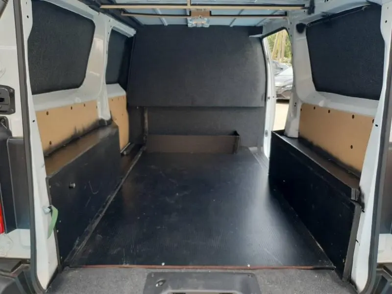 Vue intérieure arrière du Peugeot Expert Fourgon blanc XL, montrant l'espace de chargement avec plancher noir et parois protégées.
