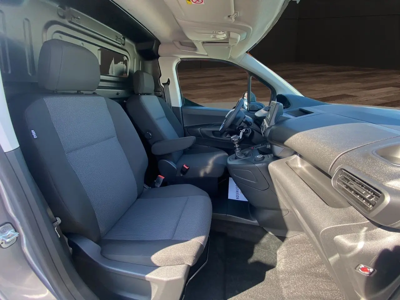 Intérieur du Peugeot Partner Fourgon Dangel 4x4 2025 vu côté droit, sièges tissus noirs et tableau de bord gris.