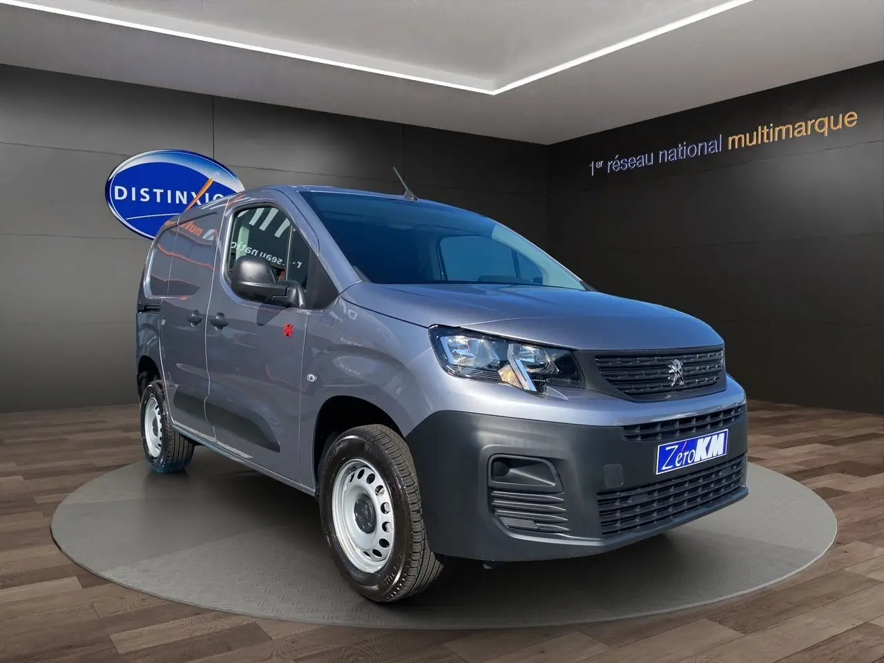 Vue 3/4 avant droite du Peugeot Partner Fourgon Dangel 4x4 gris Artense métallisé avec jantes tôles et pare-chocs noirs.