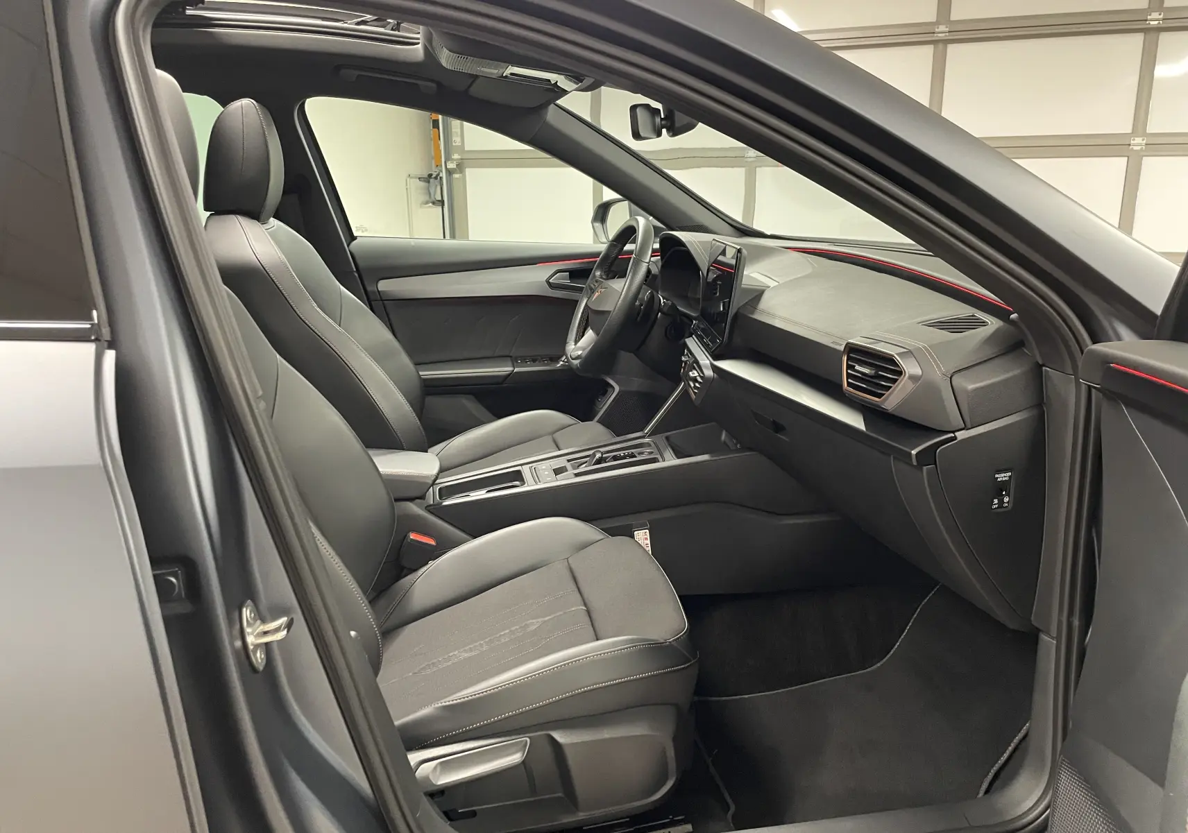 Intérieur côté conducteur du CUPRA Formentor 1.5 TSI 2023 avec sièges cuir noirs et détails rouges sur tableau de bord.