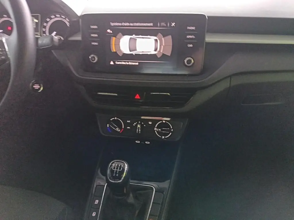 Vue intérieure centrée sur la console centrale de la Skoda Fabia 2022, avec écran tactile et levier de vitesse manuel.