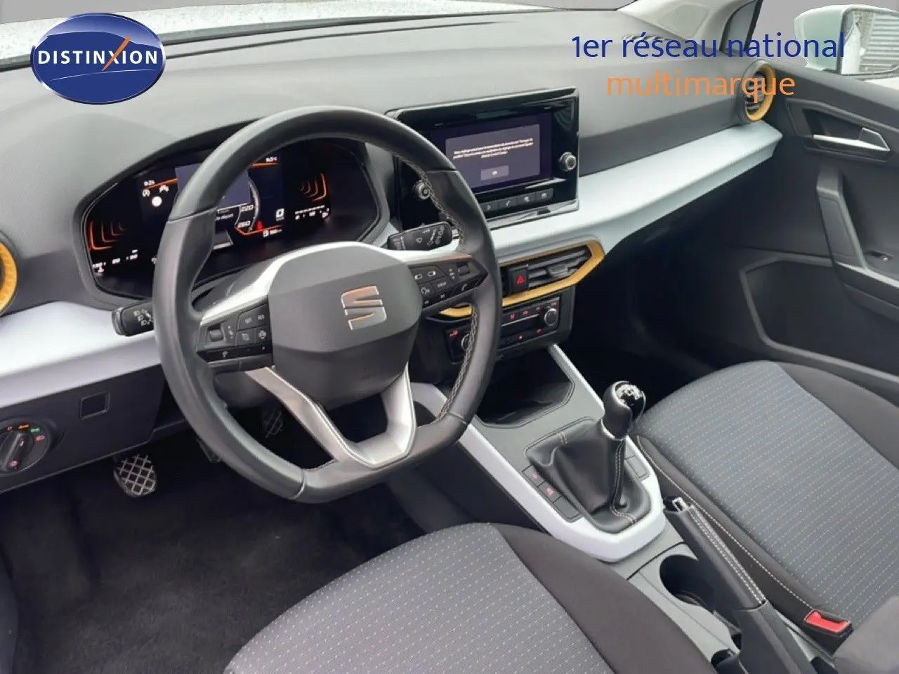 Vue intérieure côté conducteur du tableau de bord et volant cuir noir de la SEAT Arona 2025, avec levier de vitesses manuel.