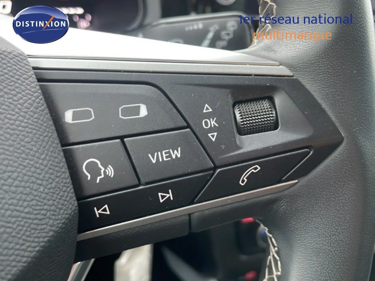 Gros plan sur les commandes au volant du SEAT Arona 2025, boutons noirs avec fonctions vocales et appel téléphonique.