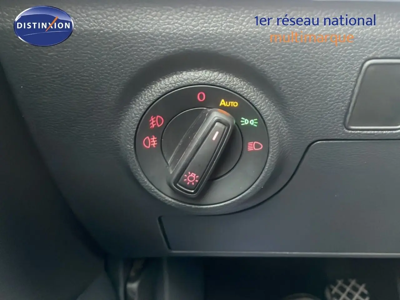 Gros plan sur le bouton de commande des phares dans l’habitacle noir du SEAT Arona blanc au toit noir.