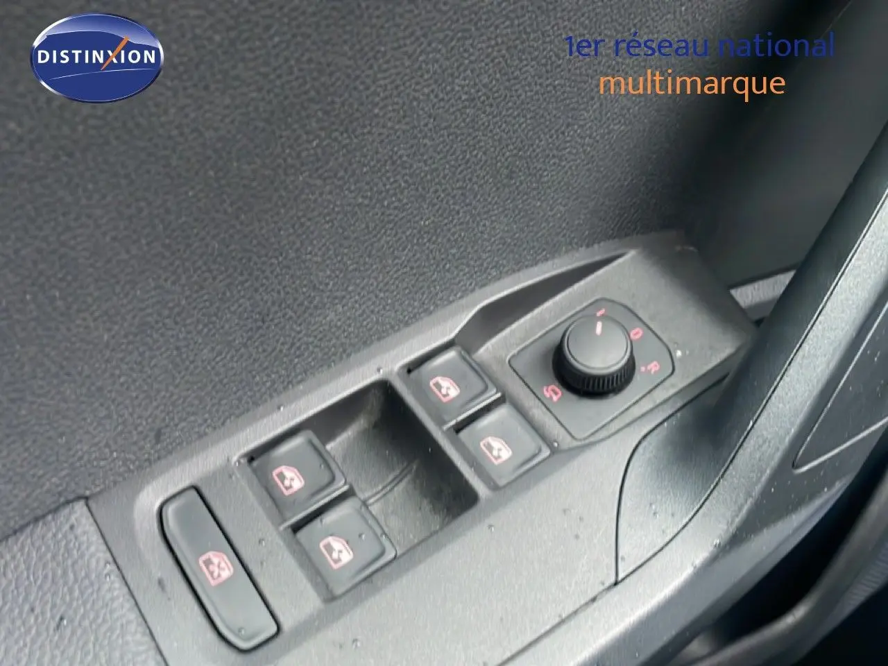 Gros plan sur les commandes des vitres et rétroviseurs côté conducteur d’un SEAT Arona 2025, intérieur noir.