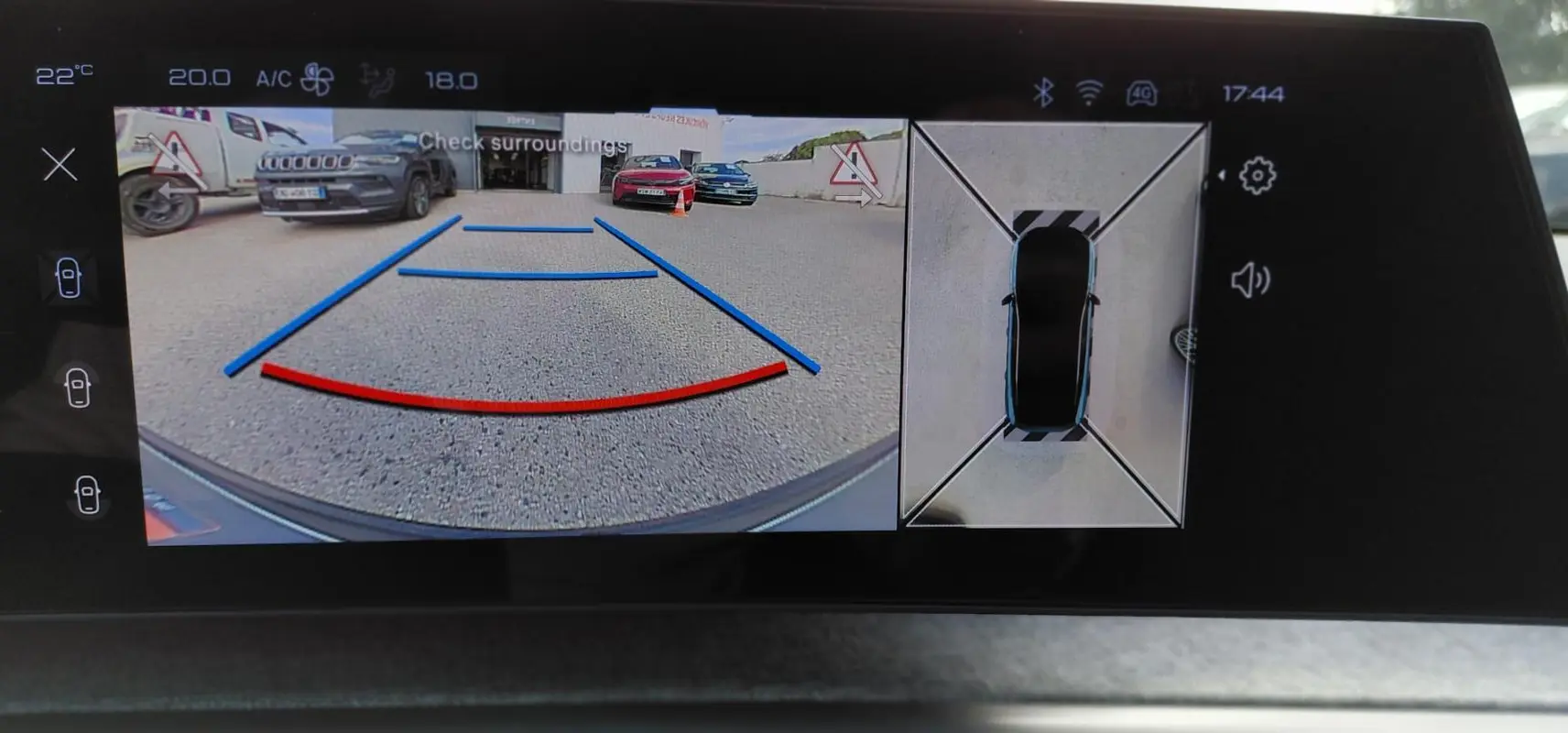 Vue écran multimédia du Peugeot 3008 Hybrid noir 2025 montrant la caméra de recul et la vue 360° du véhicule en stationnement.