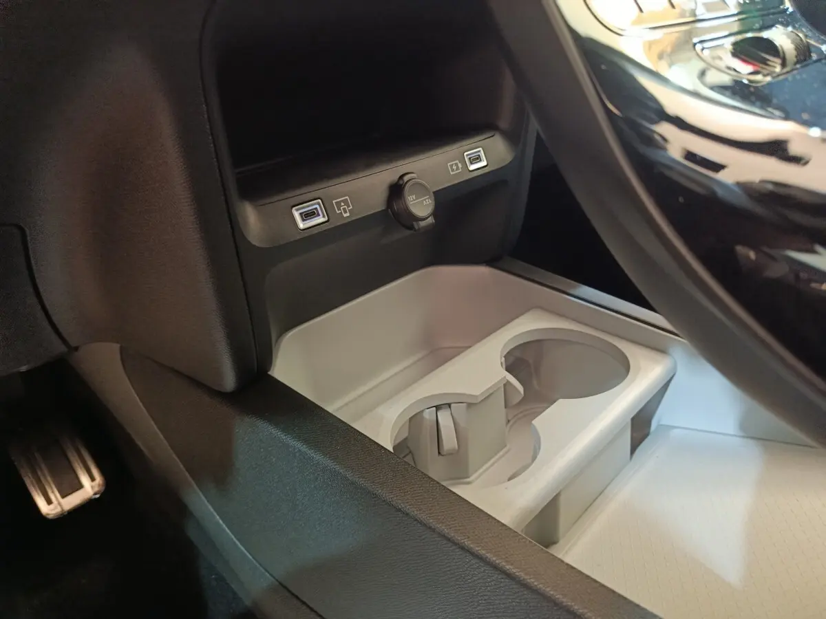 Gros plan intérieur sur la console centrale de la Citroën C5 Hybride noire, avec ports USB et prise 12V visibles.