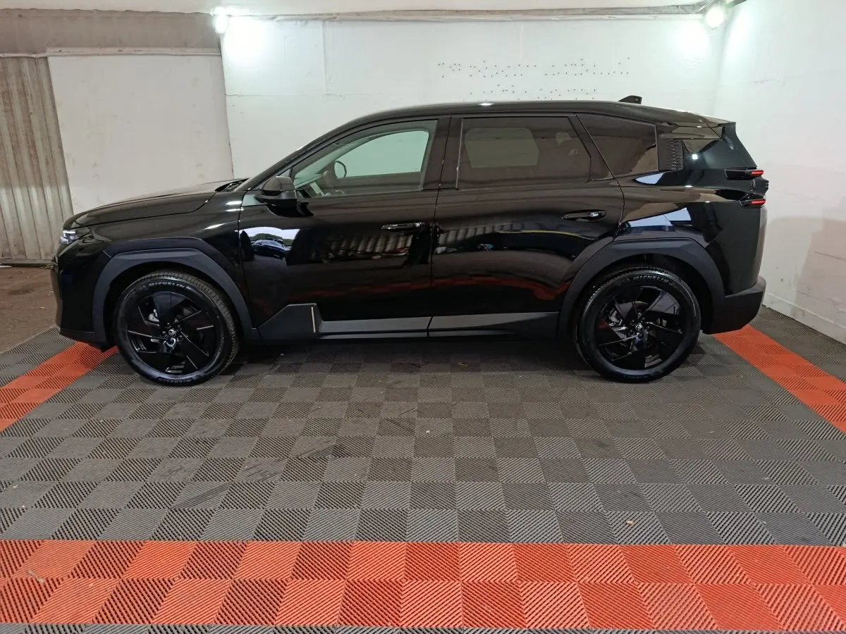 Profil côté gauche d’un Citroën C5 hybride noir 2026 avec jantes noires et lignes modernes marquées.