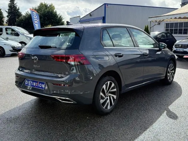 Vue frontale d'une Volkswagen Golf VIII 1.4 e-Hybrid gris dauphin avec calandre et logo VW bien visibles.