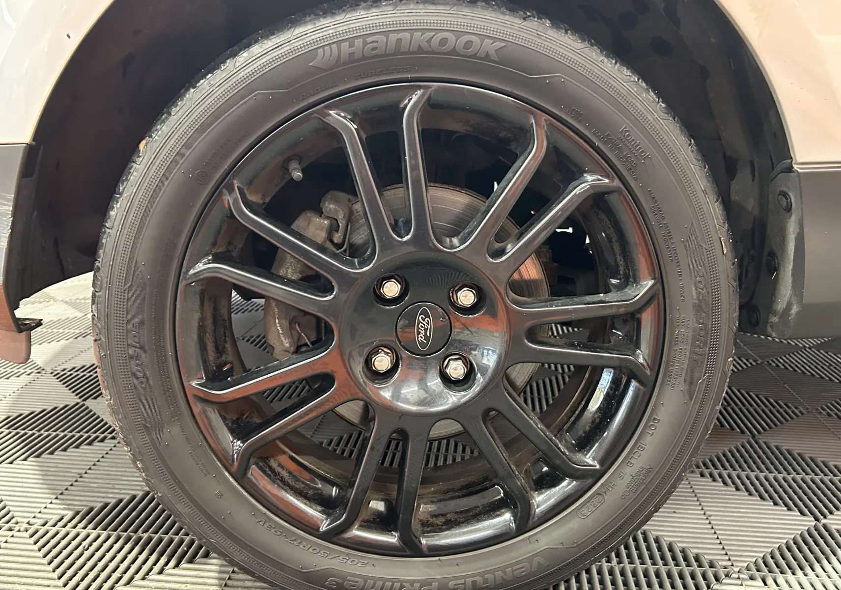 Gros plan sur la jante noire en alliage du Ford EcoSport gris avec pneu Hankook, montrant le logo Ford central.