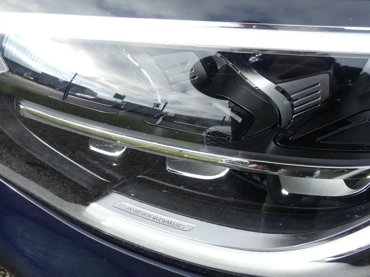 Gros plan sur le phare LED haute performance du Mercedes GLC Coupé 300 hybride bleu foncé, soulignant ses détails techniques.