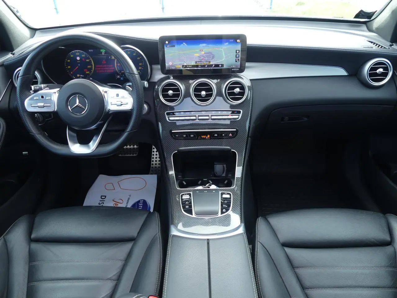 Intérieur Mercedes GLC Coupé 300 hybride 2022, tableau de bord noir avec écran central et volant multifonction cuir.