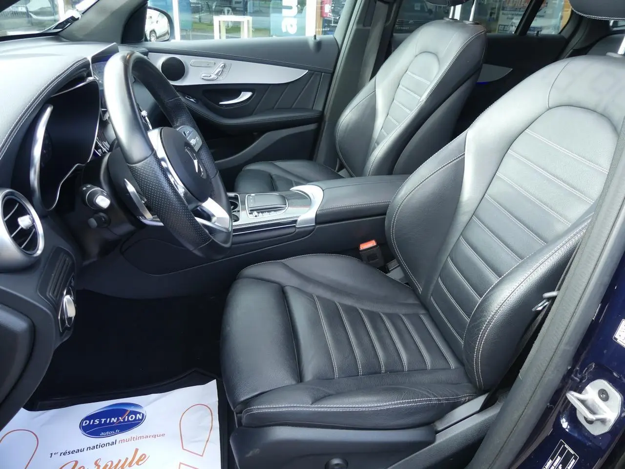 Intérieur avant droit d'une Mercedes GLC Coupé 300 hybride, sièges cuir noir et garnitures AMG carbone.