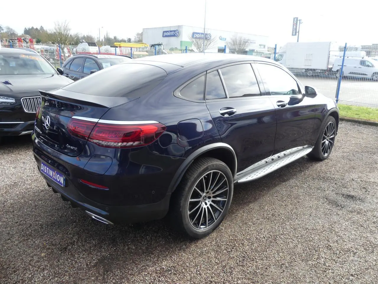 Mercedes GLC Coupé 300 hybride bleu foncé vu en 3/4 arrière droit avec jantes AMG et marchepieds inox