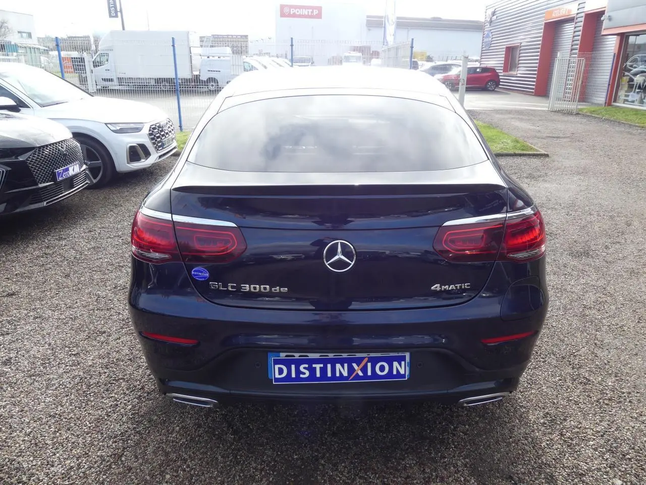 Vue arrière d'un Mercedes GLC 300 de hybride bleu foncé avec logo 4MATIC et doubles sorties d'échappement chromées.