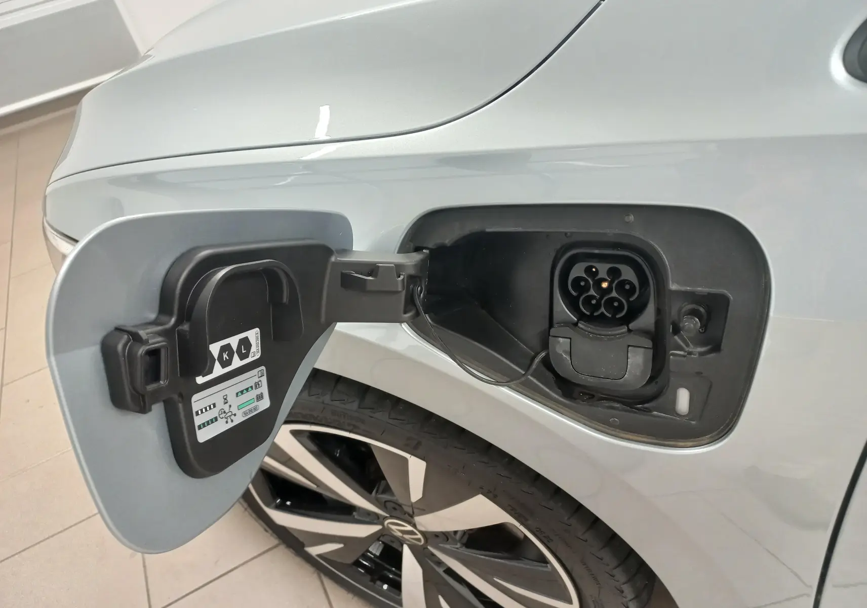 Prise de recharge ouverte côté arrière gauche d’une Volkswagen Golf 1.5 eHybrid 204 DSG6 argent Dolomite avec jante alliage 18 pouces.