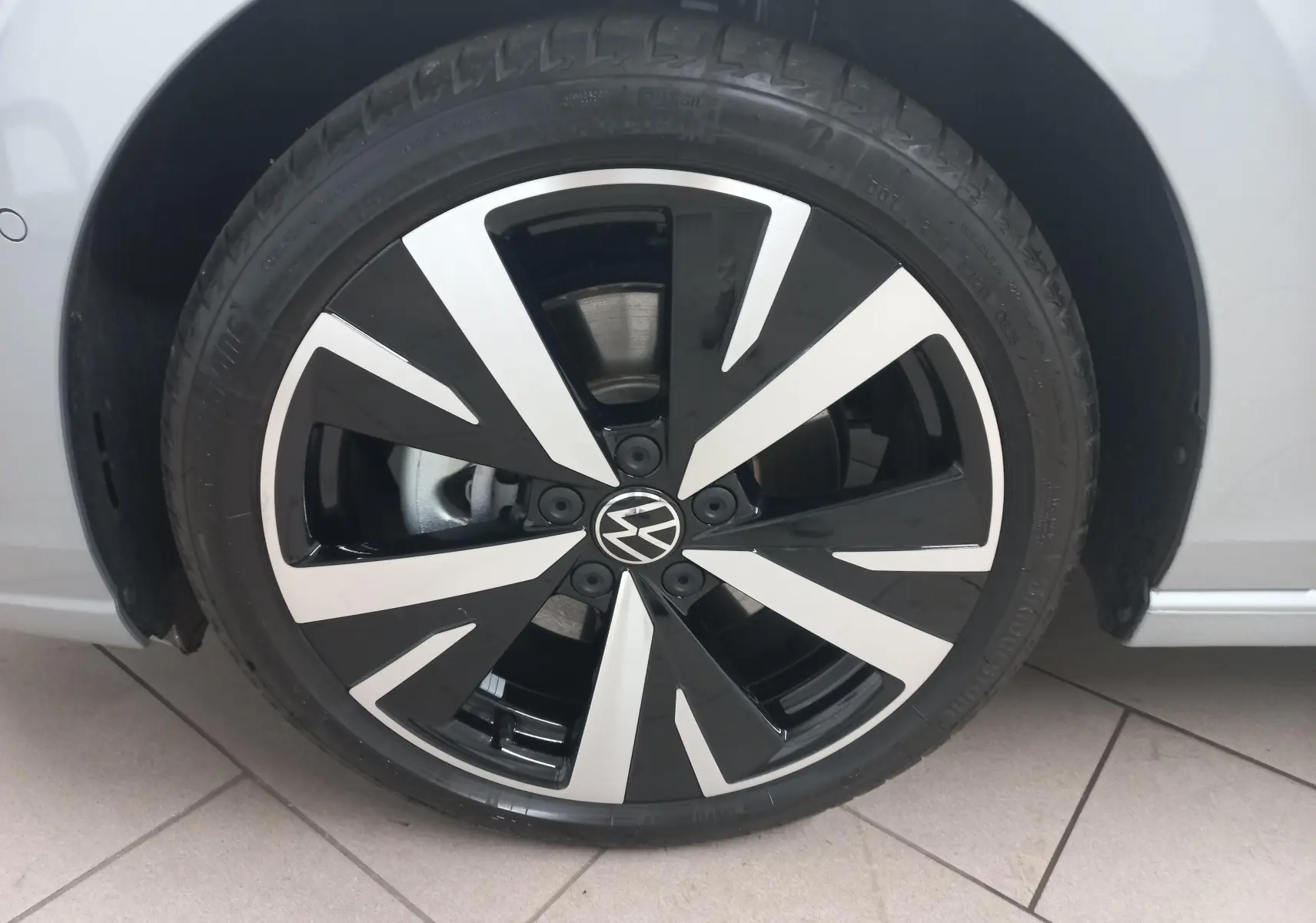Gros plan sur la jante alliage léger 18'' Catania noire et argentée de la Volkswagen Golf 1.5 eHybrid 2025 couleur Argent Dolomite.