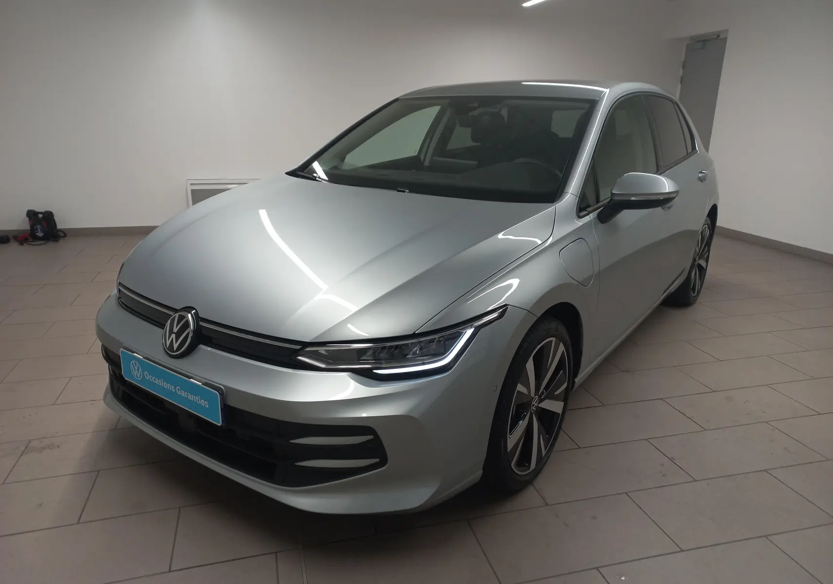 Volkswagen Golf 1.5 eHybrid 2025 en Argent Dolomite, vue 3/4 avant droit avec jantes alliage 18 pouces Catania.
