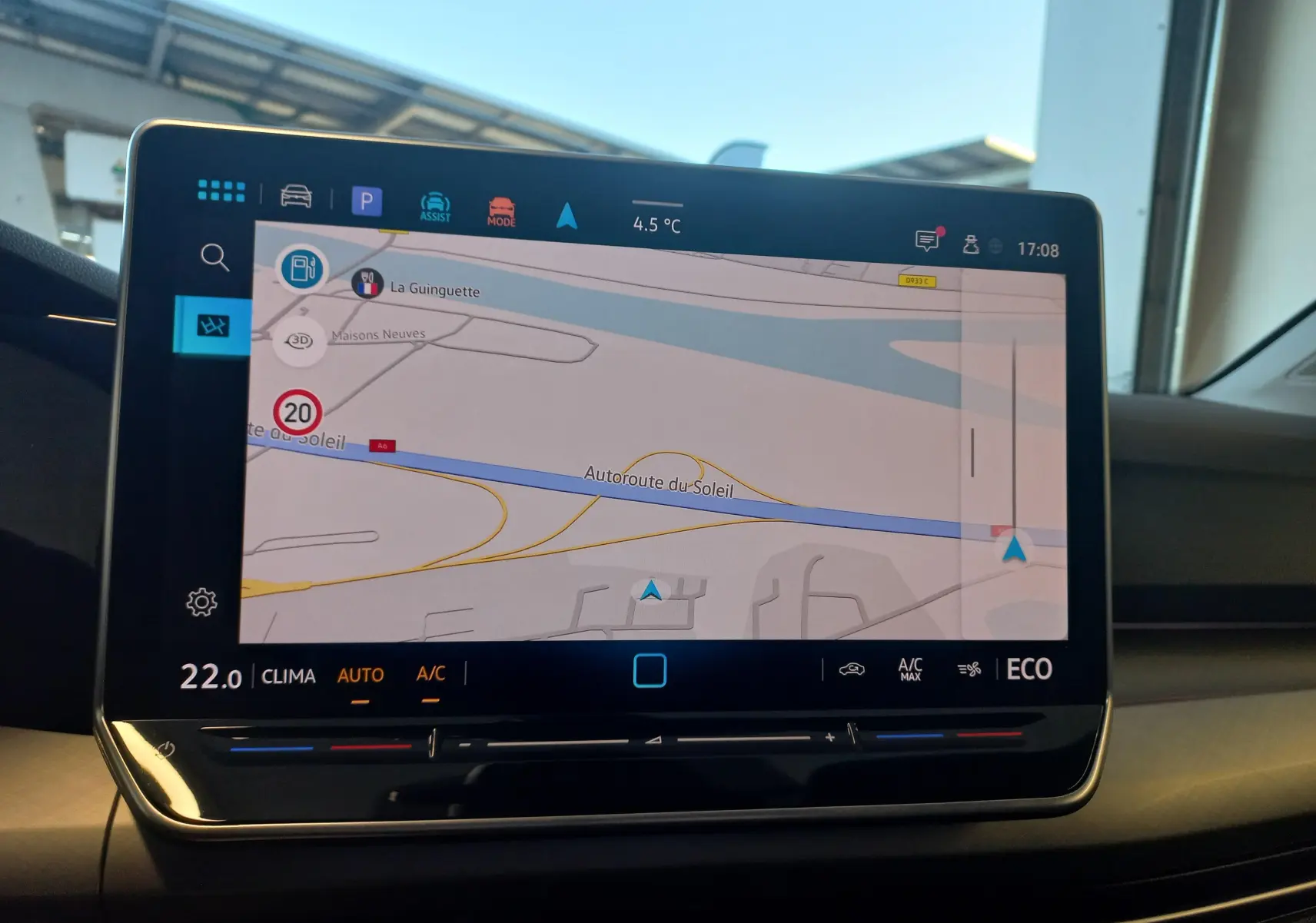 Écran tactile central de navigation de la Volkswagen Golf 1.5 eHybrid 2025, affichant la carte et les réglages climatiques.