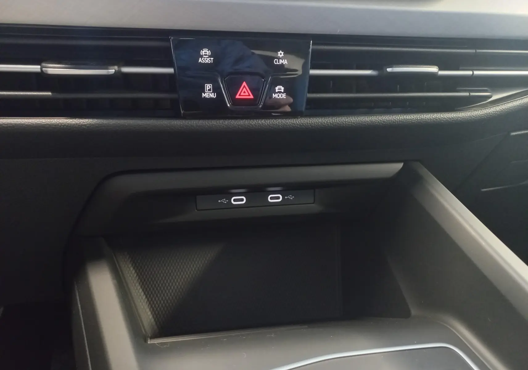 Gros plan sur la console centrale de la Volkswagen Golf 1.5 eHybrid 2025, avec commandes tactiles et ports USB-C.