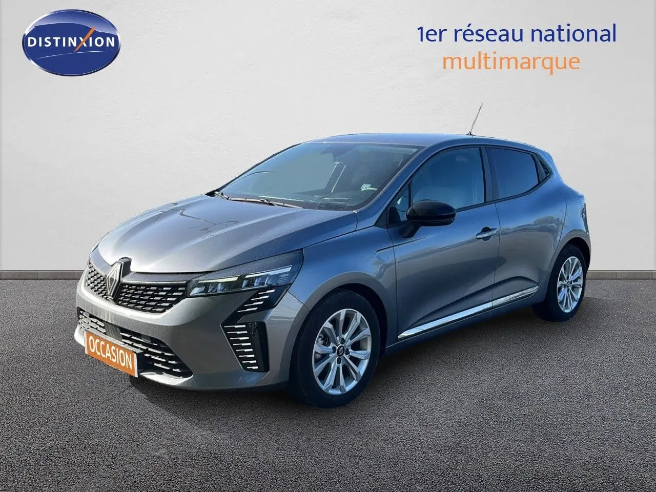 Renault Clio 2025 gris schiste métal vue 3/4 avant droit avec calandre distinctive et jantes alliage.