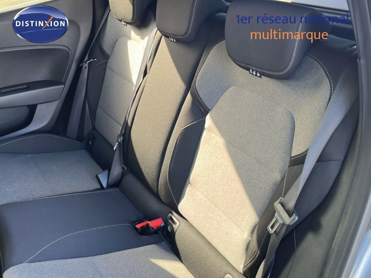 Vue rapprochée des sièges arrière gris tissu de la Renault Clio 2025, montrant les ceintures et les appuie-têtes.