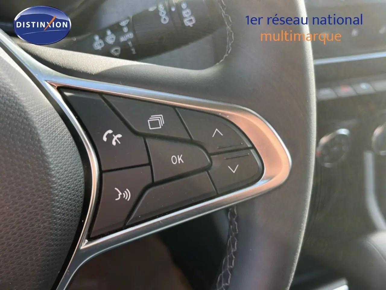 Gros plan sur les commandes multifonctions à gauche du volant cuir noir de la Renault Clio 2025, boutons noirs et chrome.