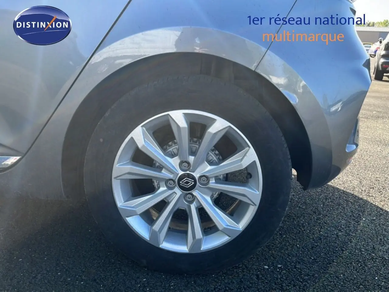 Gros plan sur la roue avant droite d'une Renault Clio gris schiste métal, mettant en valeur la jante alu moderne.