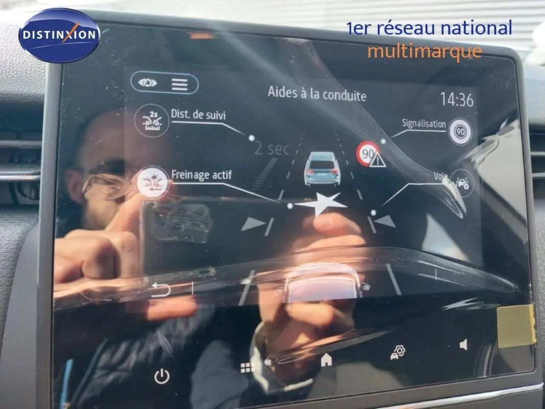 Écran tactile du système d’aide à la conduite de la Renault Clio blanche, affichant régulateur et détection panneaux.