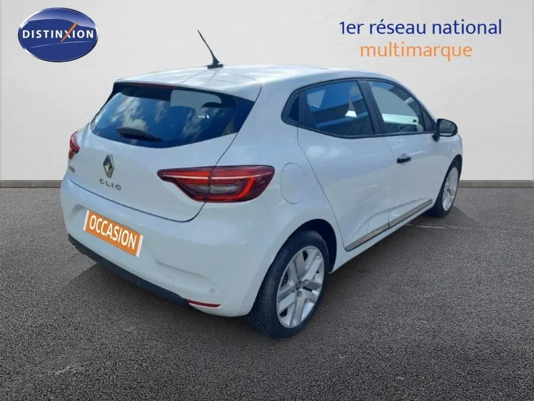 Vue 3/4 arrière droite d'une Renault Clio blanche 2020, avec feux arrière allumés et plaque "OCCASION" visible.
